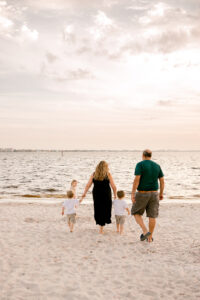 A family walks on the beach at sunset