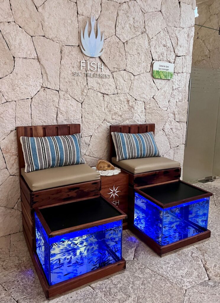 Luxury fish spa foot treatment stations with blue-lit tanks inside the spa at Secrets Maroma Beach in Mexico